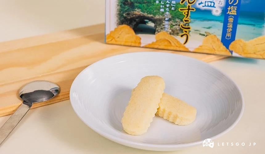 白盤盛裝條狀點心與湯匙,後方立牌盒