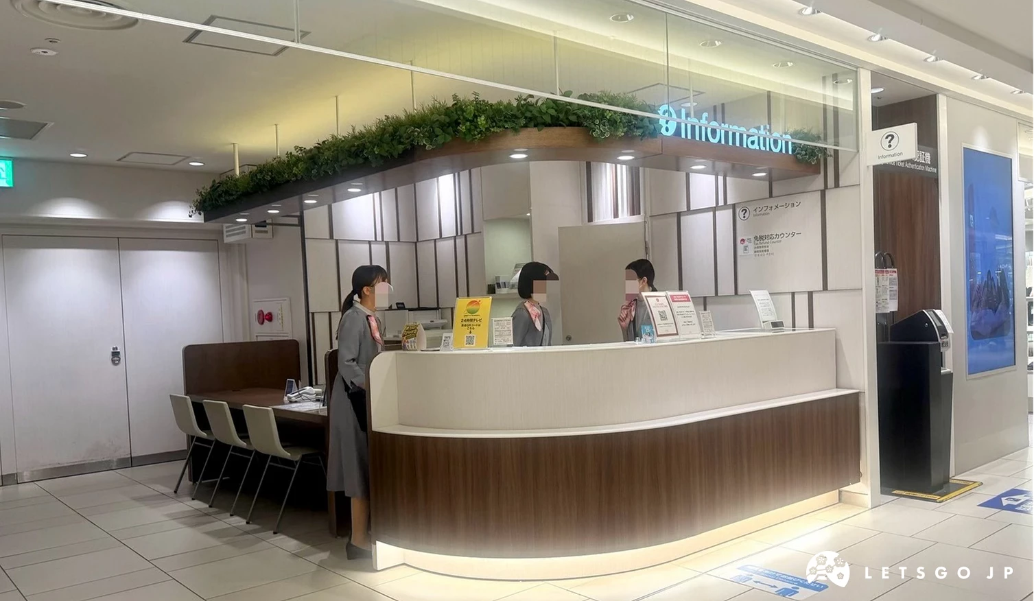 商場服務台(Information counter),弧形木質櫃檯前有身穿制服的服務人員,背景設有綠植與服務標誌。