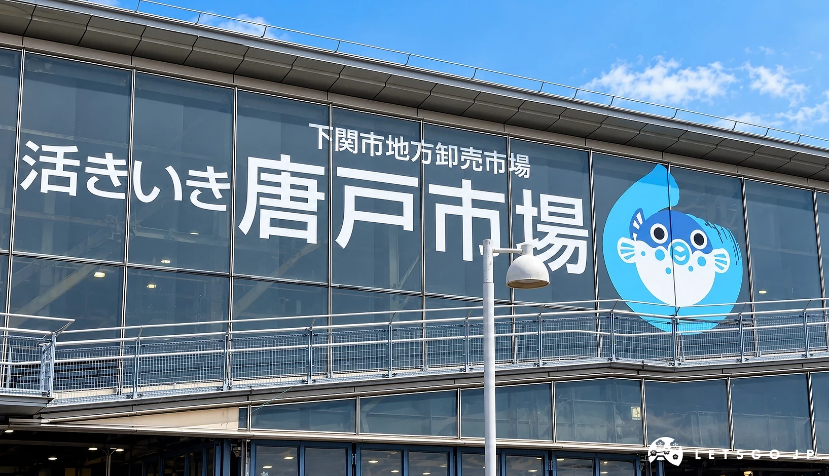 建築外牆寫有「唐戶市場」與日文標語,右側有藍色河豚圖案