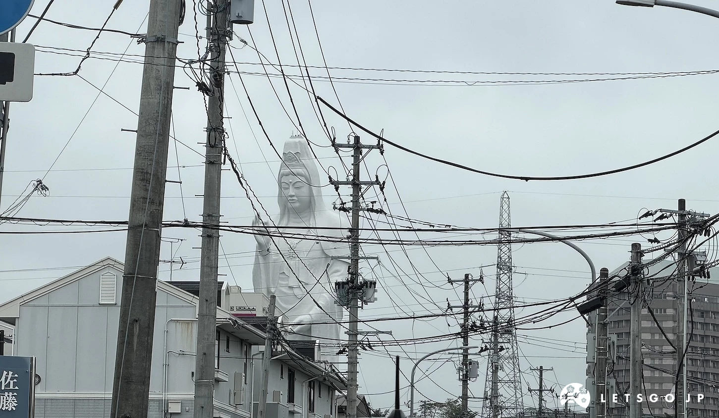 電線與住宅後方現身的白色觀音像