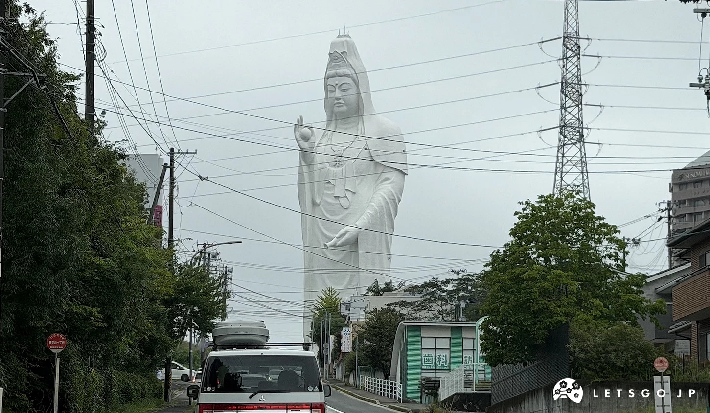 道路盡頭矗立的白色觀音與電塔