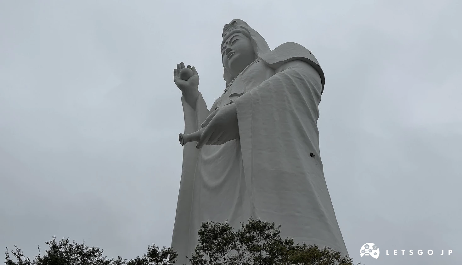從樹叢後方仰望的白衣觀音全身