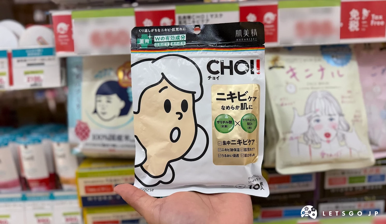 在藥妝店內貨架前,手拿著畫著女孩插畫的面膜