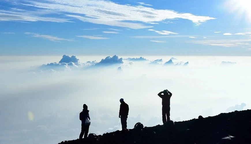 幾名登山客在富士山山頂觀望周遭環境