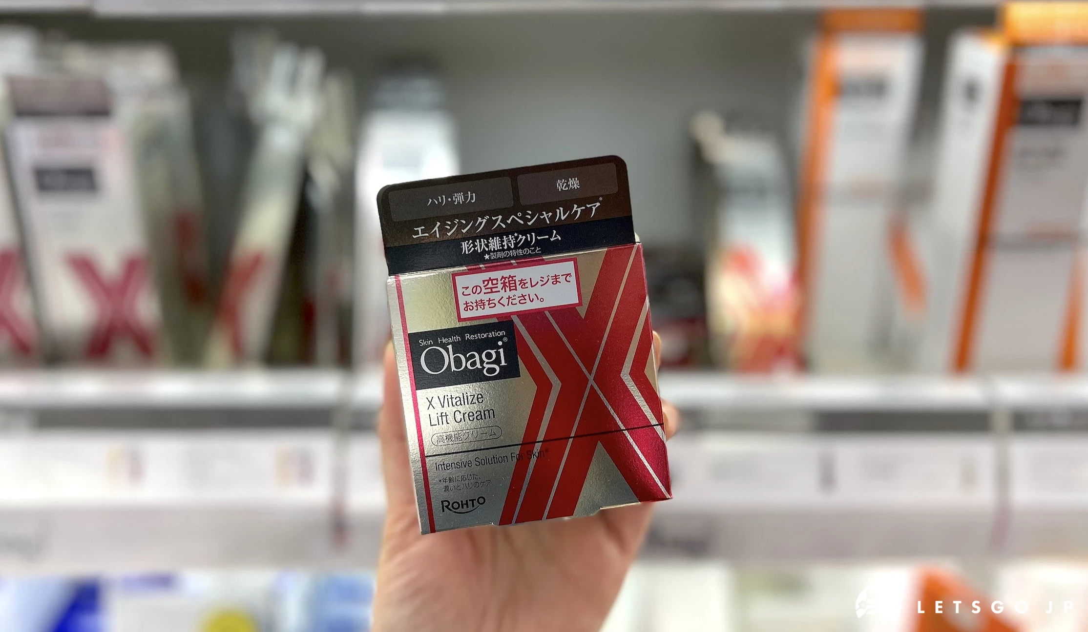 在藥妝店內貨架前,手拿著金色盒子保養品