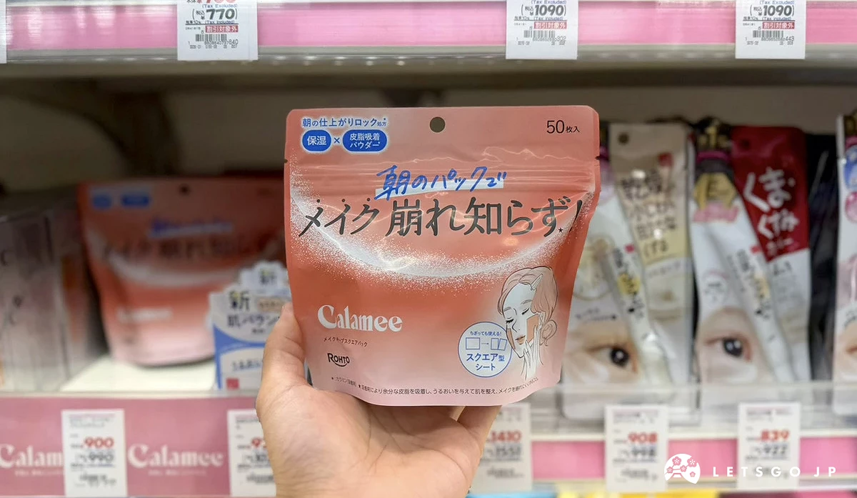 在藥妝店內貨架前,手拿著粉色袋裝面膜