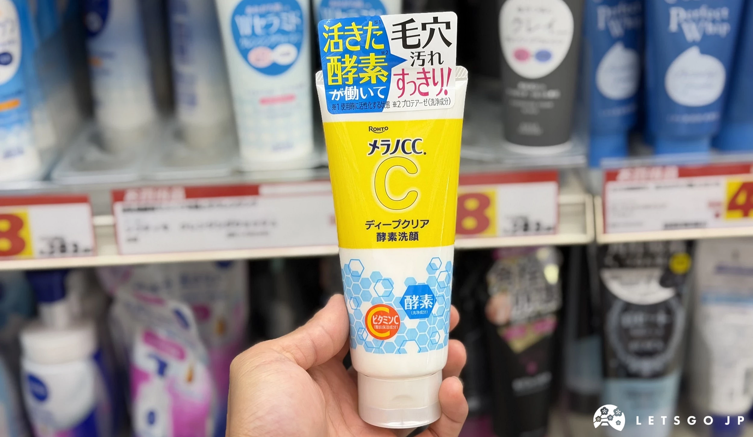 在藥妝店內貨架前,手拿著黃色的保養品