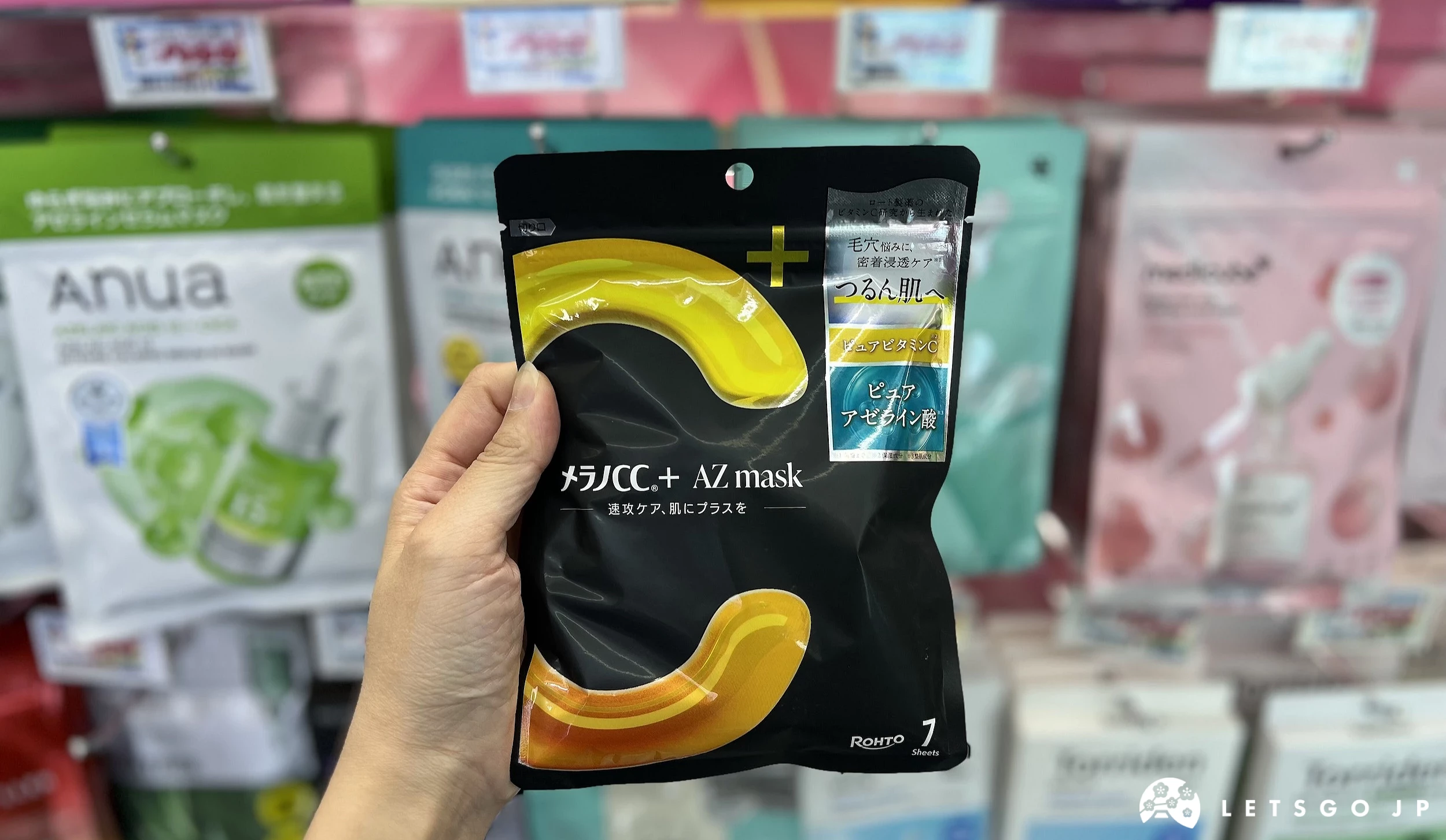 在藥妝店內貨架前,手拿著黑色面膜