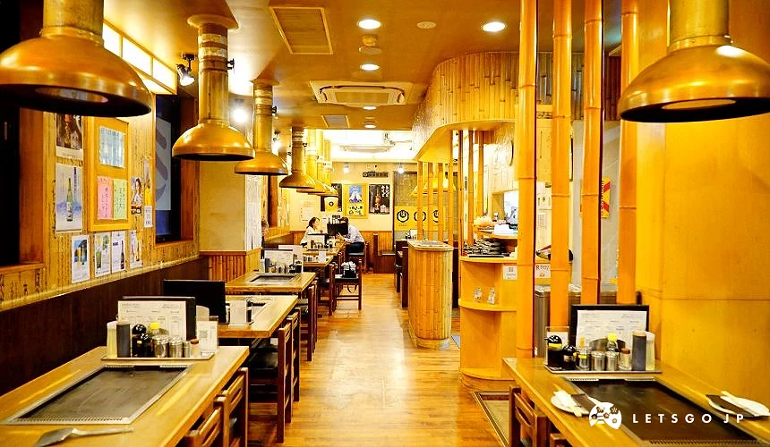 餐廳內多張嵌鐵板木桌沿走道排列,天花板垂掛圓形排煙罩