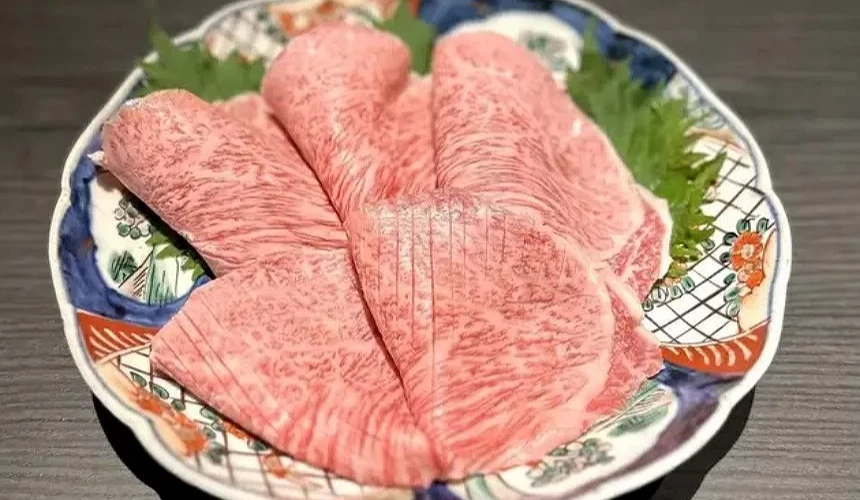 一盤生牛肉燒肉片放在盤子上。
