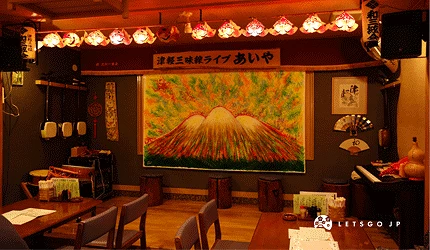 津輕三味線 あいや居酒屋店內,牆上有手繪的山壁畫