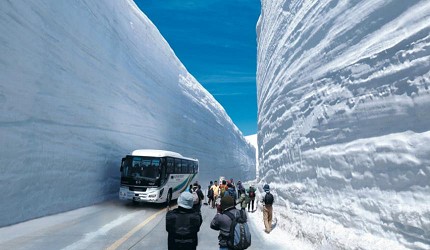 雪牆中有一輛遊覽車與遊客
