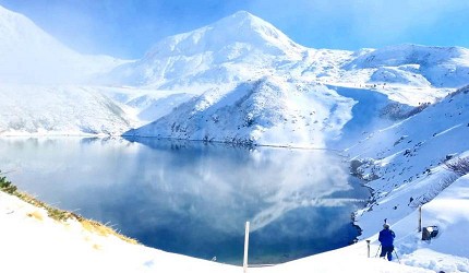 倒映著白雪靄靄山坡的湖