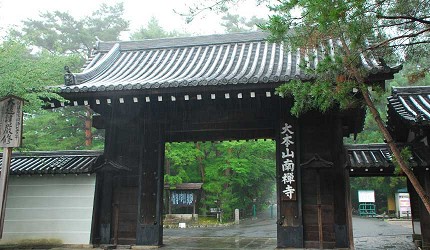 南禪寺黑色木門建築莊嚴矗立於紅葉林中，顯示古剎氣勢